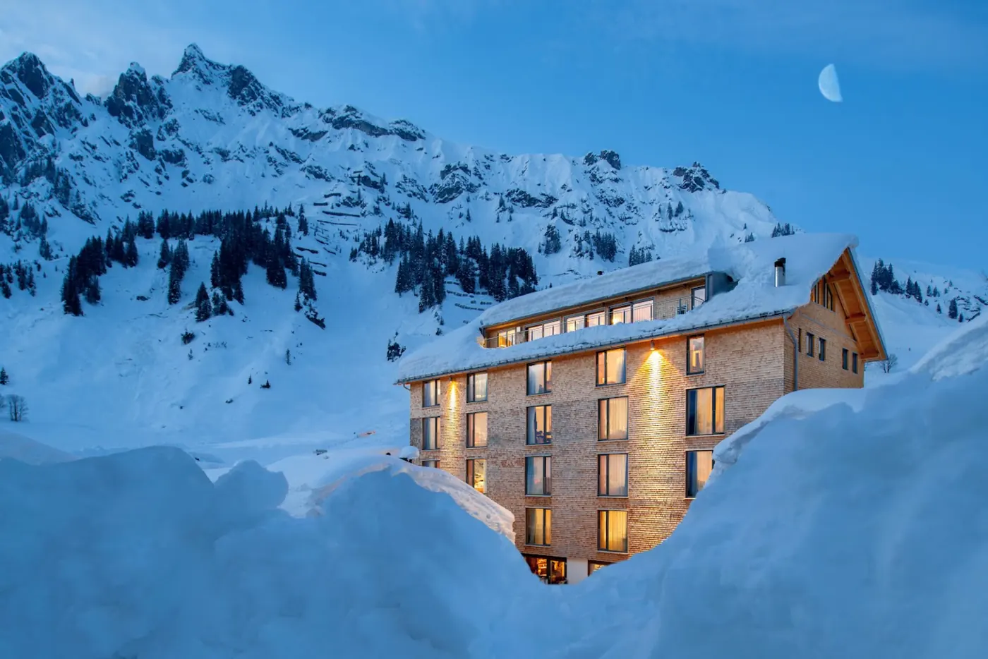 Das Ski Hotel Mondschein in Stuben in der blauen Stunde, darüber der Mond