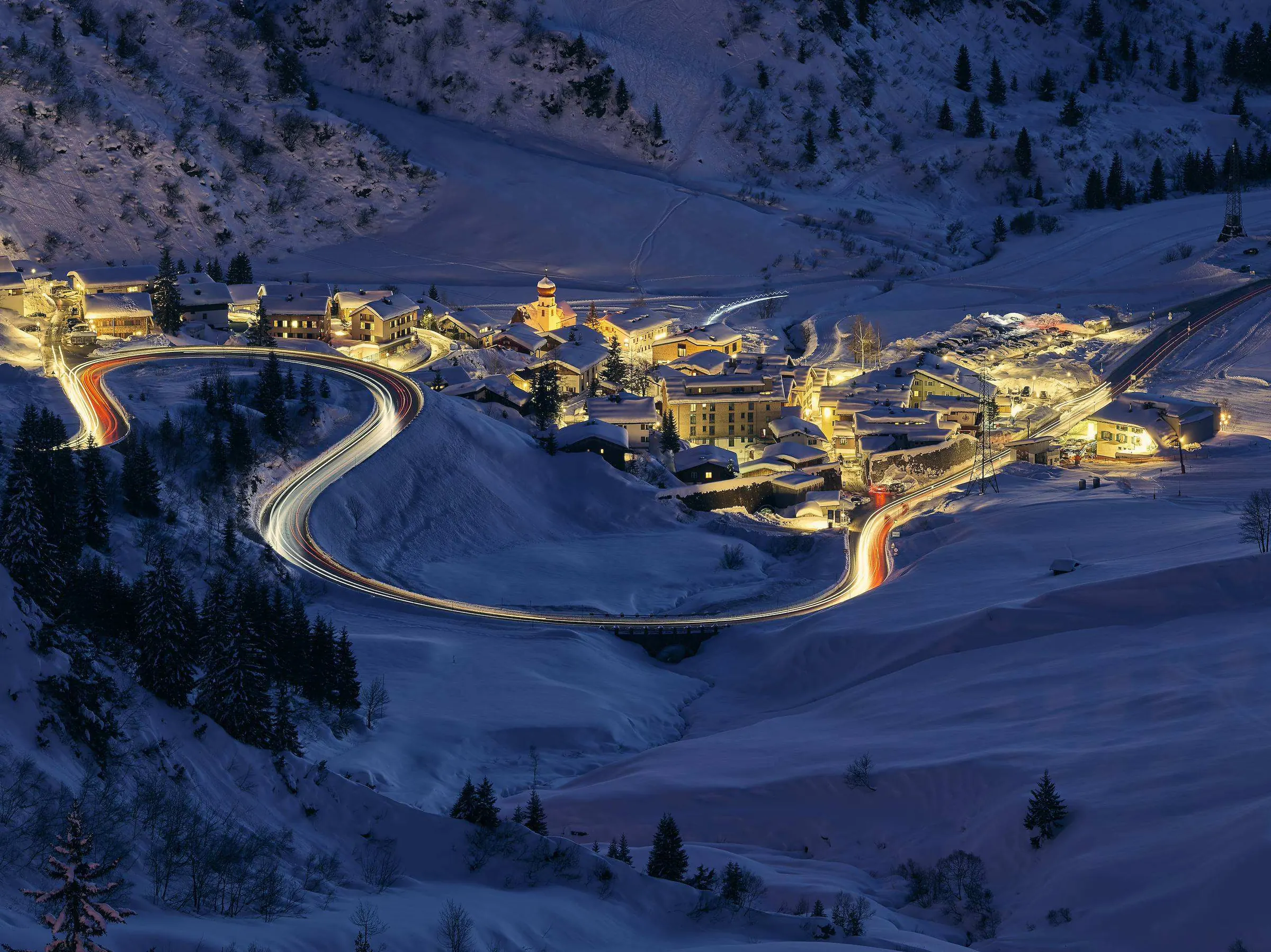 Stuben am Arlberg at night, the lit pass road winding in hairpins