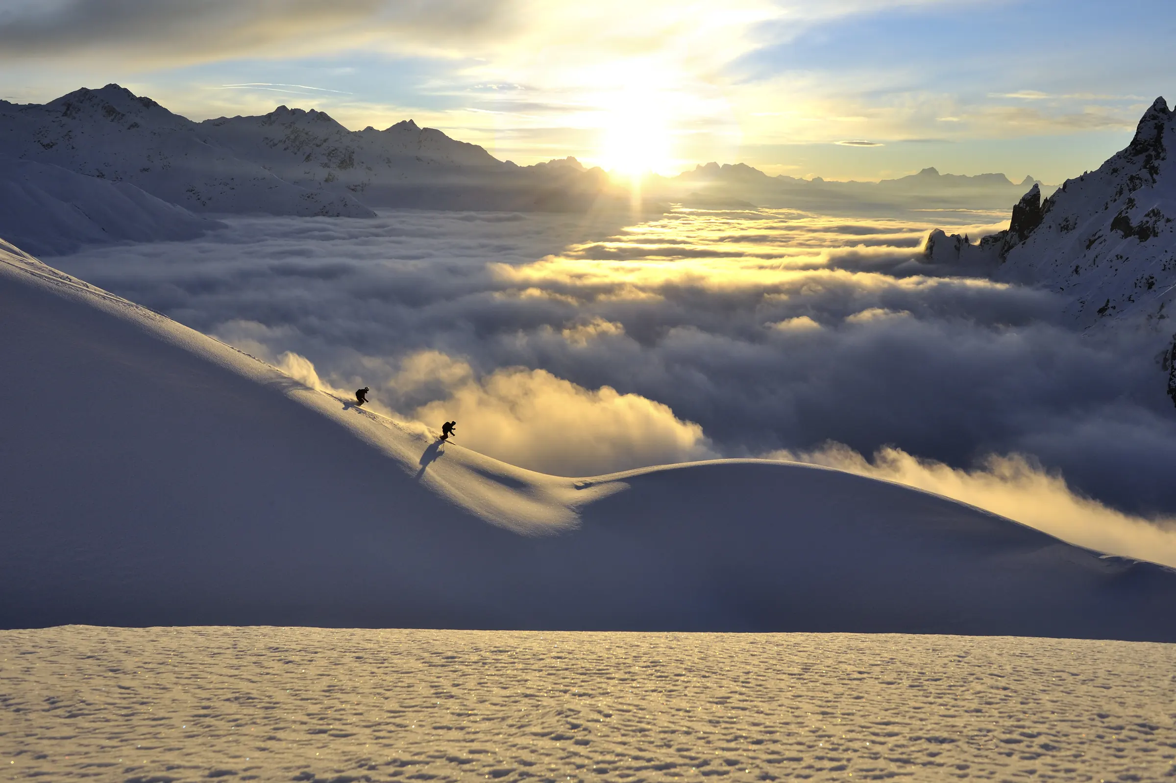 Skier in deep snow above a sea of cloud